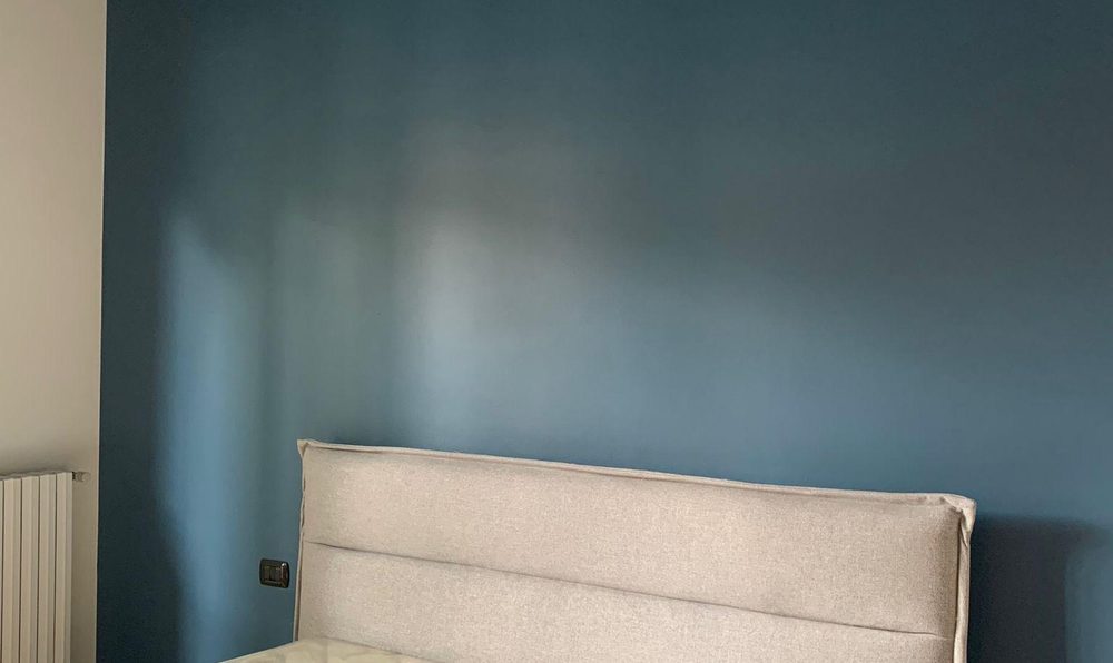 Camera da letto con parete e soffitto dipinti dello stesso blu